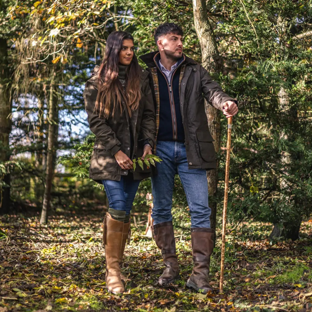 Couple strolling in autumn woods wearing the New Forest Woodsman Wax Jacket