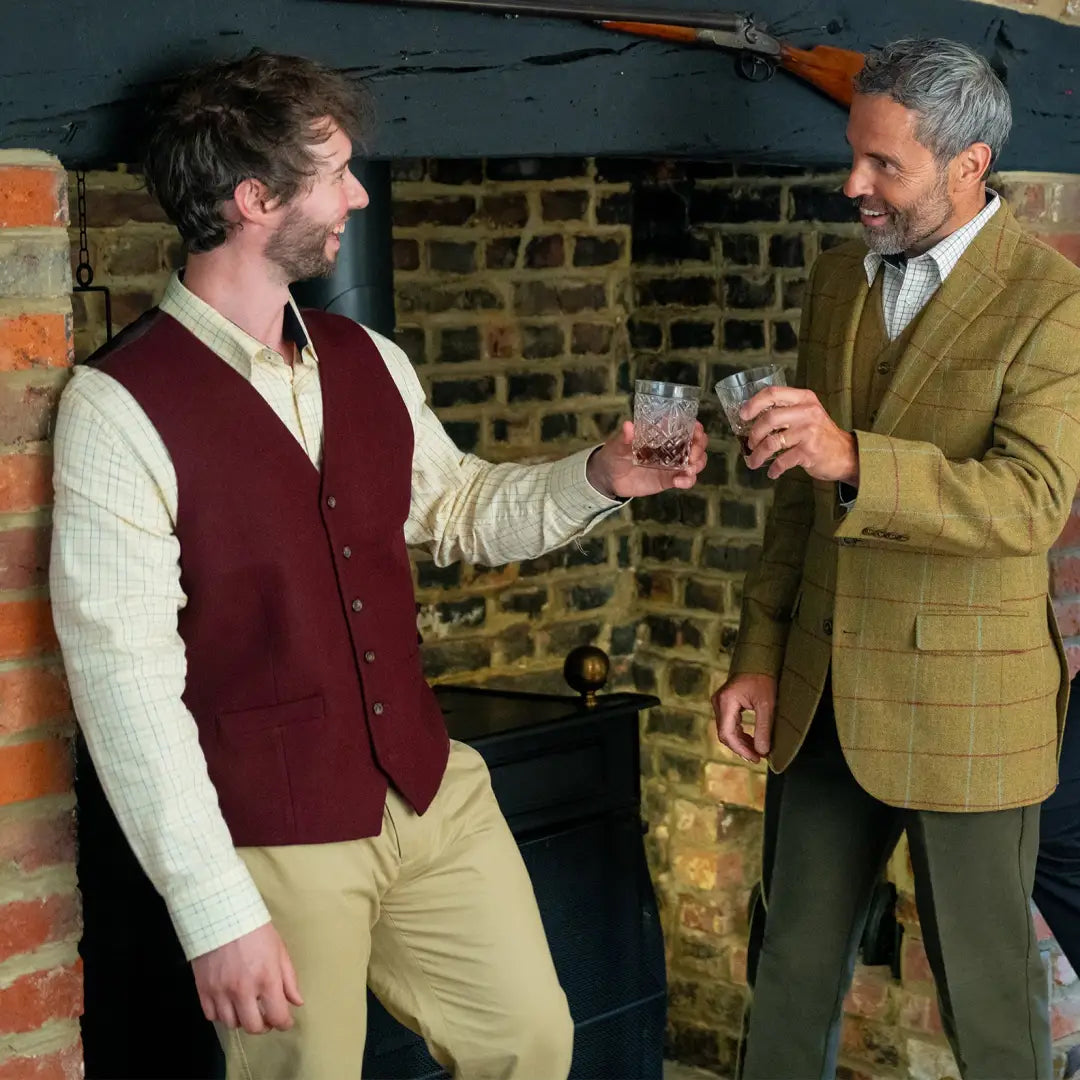 Two men toasting with whiskey, showcasing a stylish wool mix waistcoat