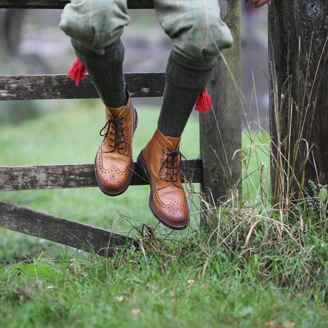 Brown leather wingtip boots with Pennine Beater Socks in premium wool and green pants