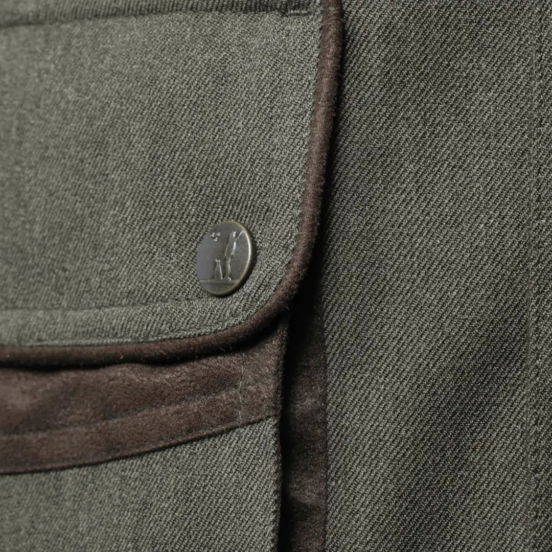 Button detail on the pocket of the Percussion Berry Jacket with brown trim