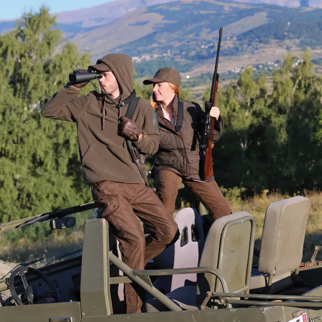 Two hunters in a Percussion Fleece Hooded Sweatshirt on a vehicle, scouting with gear