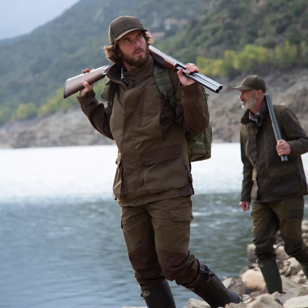 Man in Percussion Imperlight hunting trousers with a rifle over his shoulder