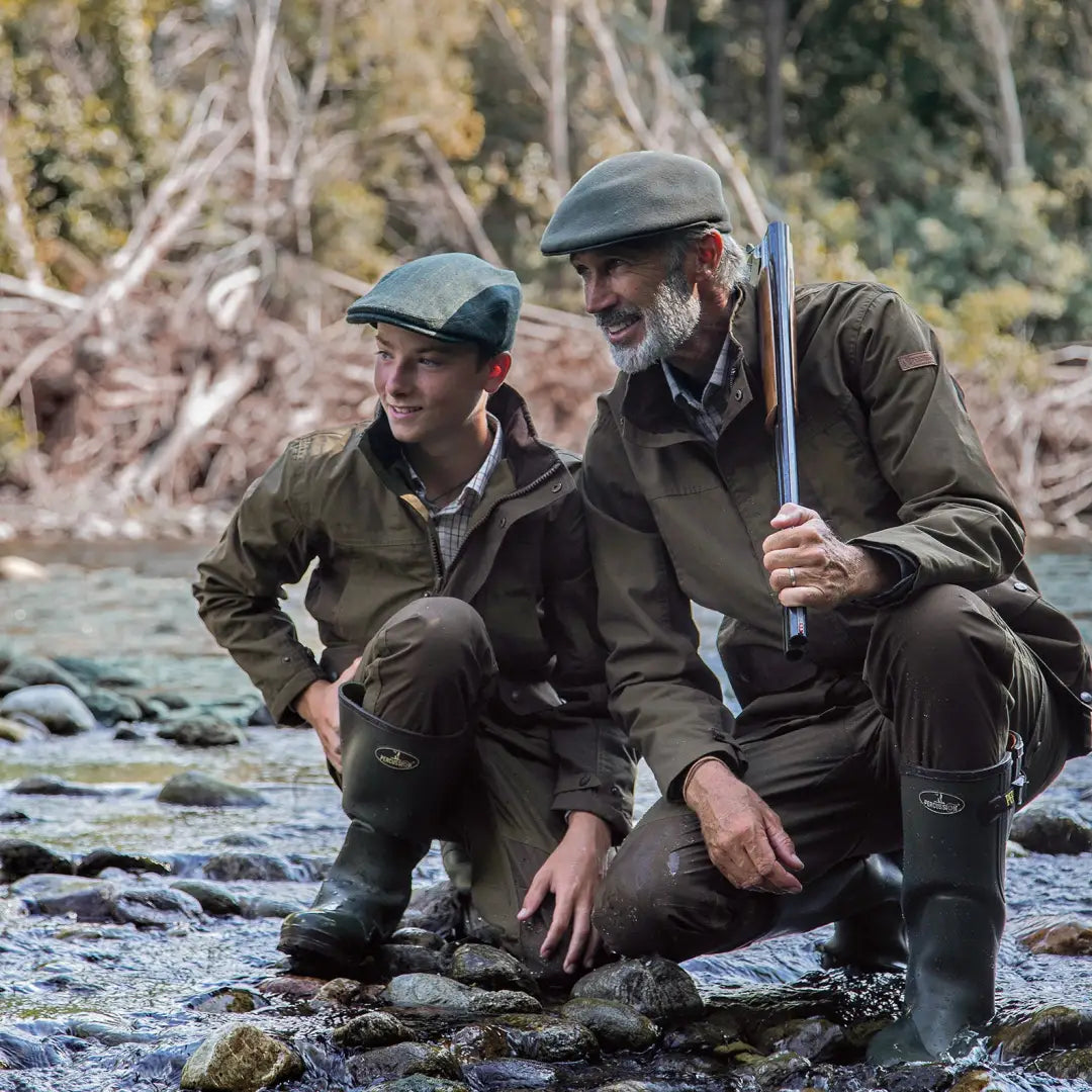 Two men in Percussion Imperlight hunting trousers crouch by a stream