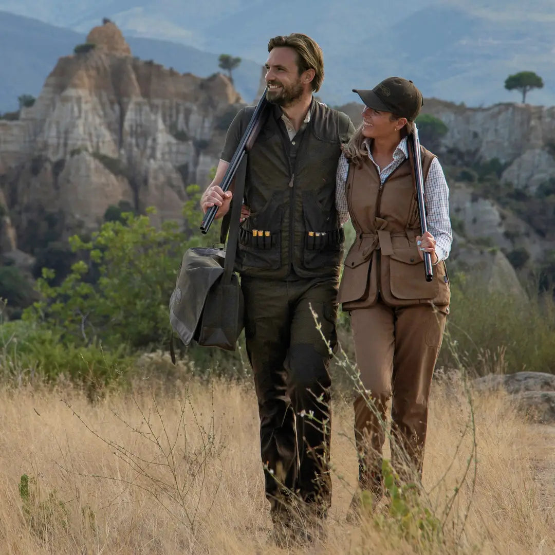 Two adventurers in Percussion Savane Hunting Trousers exploring a grassy field