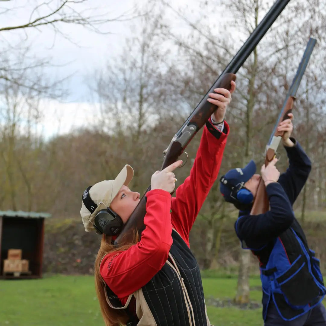 Two people enjoying clay pigeon shooting while wearing a Percussion Skeet Vest