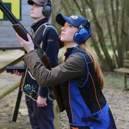 Woman in shooting gear with a shotgun wearing a Percussion Skeet Vest at the range