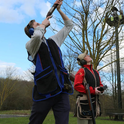 Person in a Percussion Skeet Vest pruning tree branches with a long-handled tool