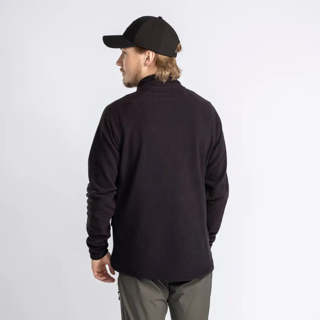 Man in black cap and sweater showcasing the Pinewood Air Vent Fleece Jacket from behind