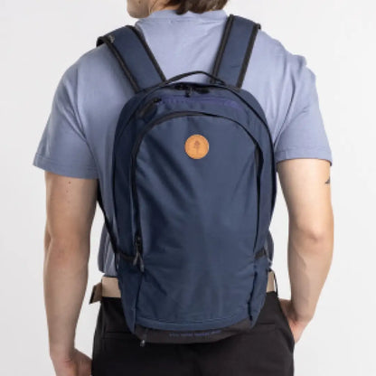 Navy blue Pinewood Day Pack 22L with orange logo on a person’s back