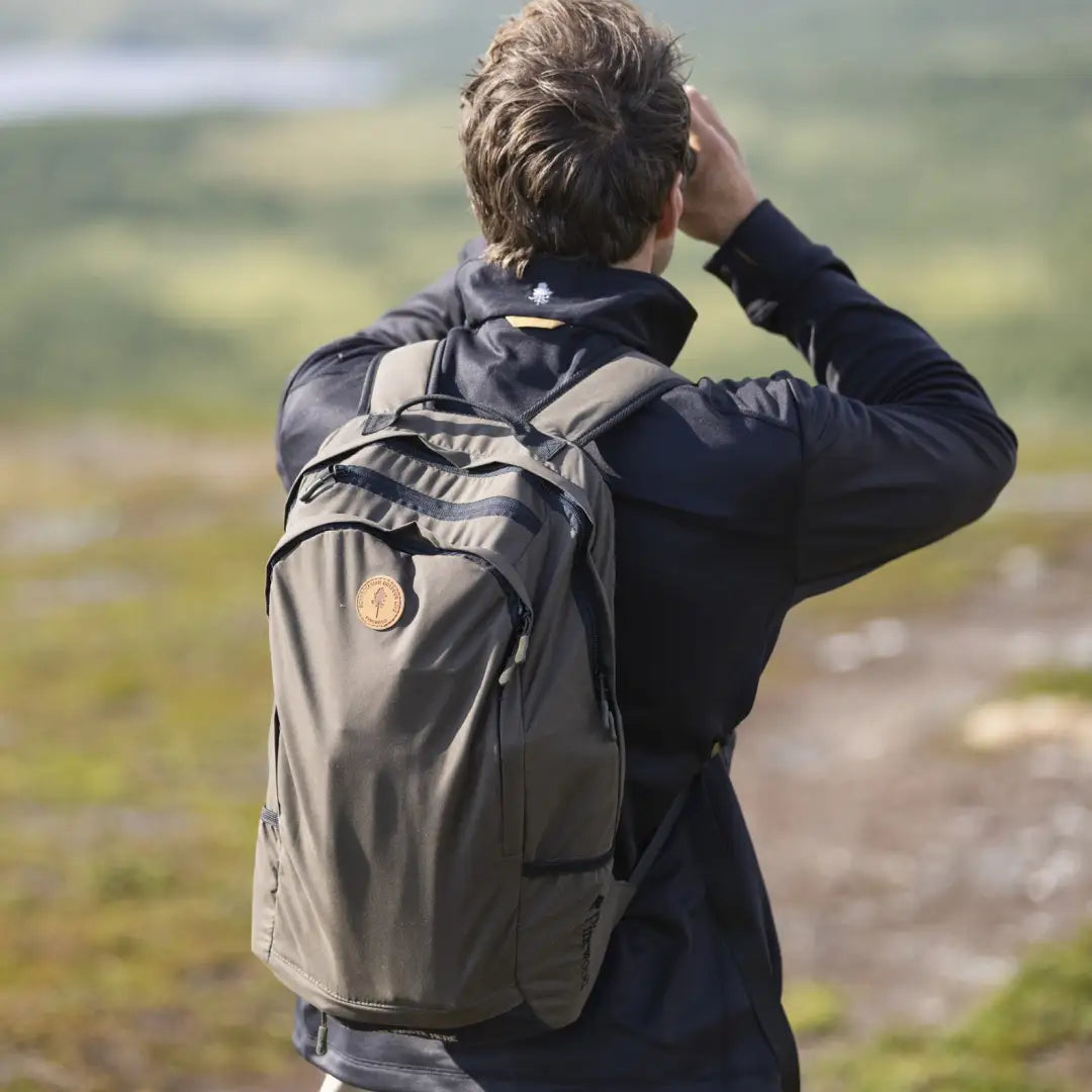 Person gazing into the distance wearing a Pinewood Day Pack 22L. Perfect for adventure!