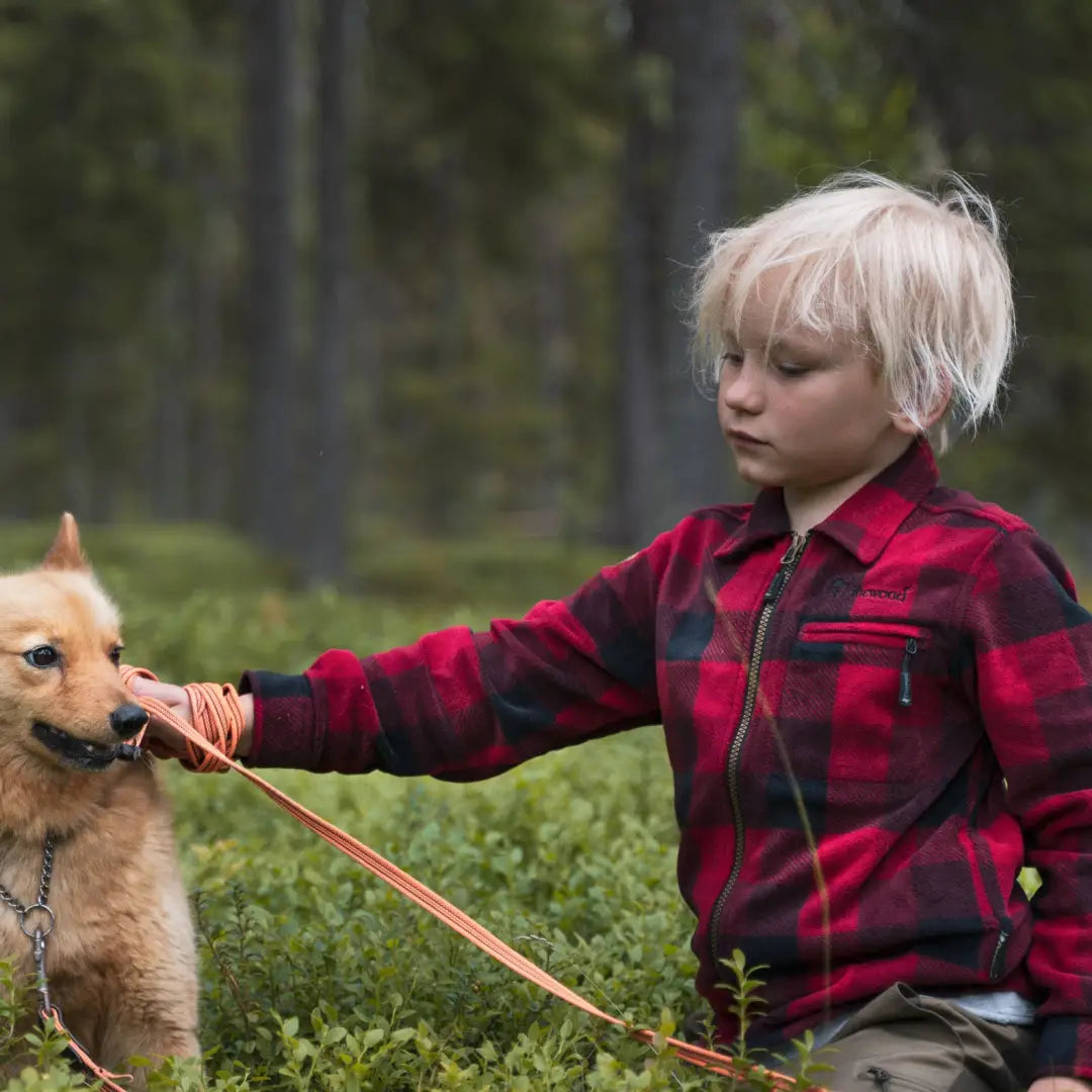 Child in a red plaid shirt with leash, showcasing Pinewood Kids Canada fleece shirt