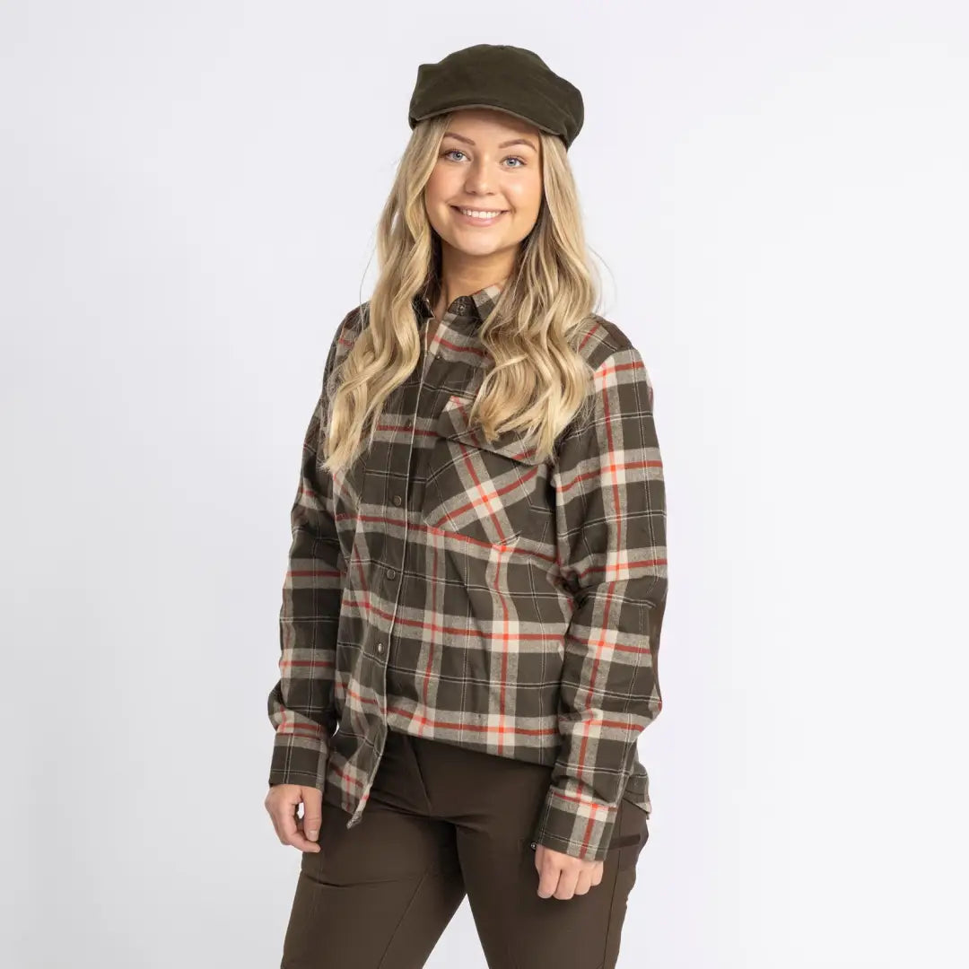 Smiling blonde woman in plaid shirt and newsboy cap, perfect for country clothing outdoors