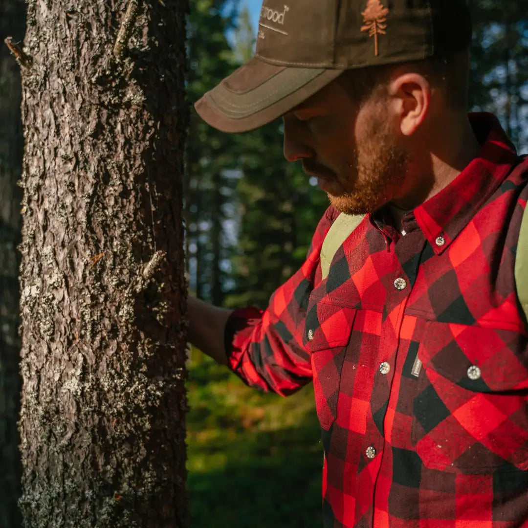 Man in a red and black plaid Pinewood Lumbo Shirt enjoying the forest vibes