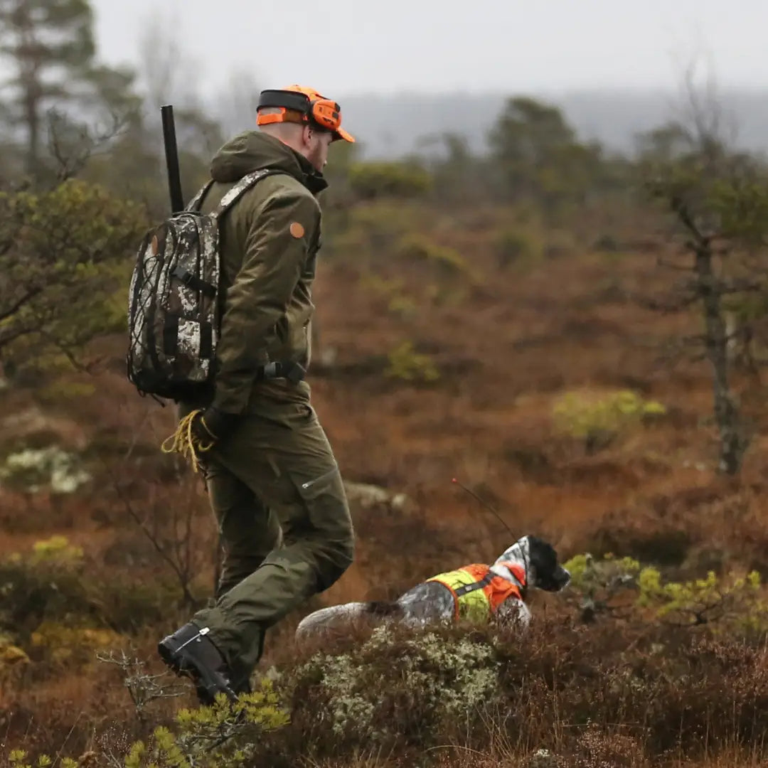 Hunter and dog in a field wearing the Pinewood Retriever Active Hunting Jacket