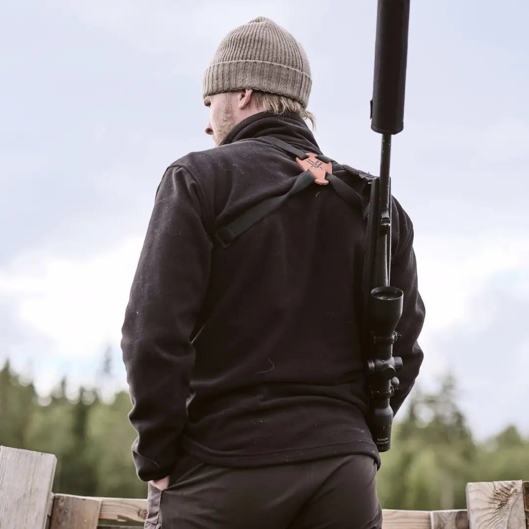 Person in dark clothes and beanie with Rifle on a Pinewood Tiveden Fleece