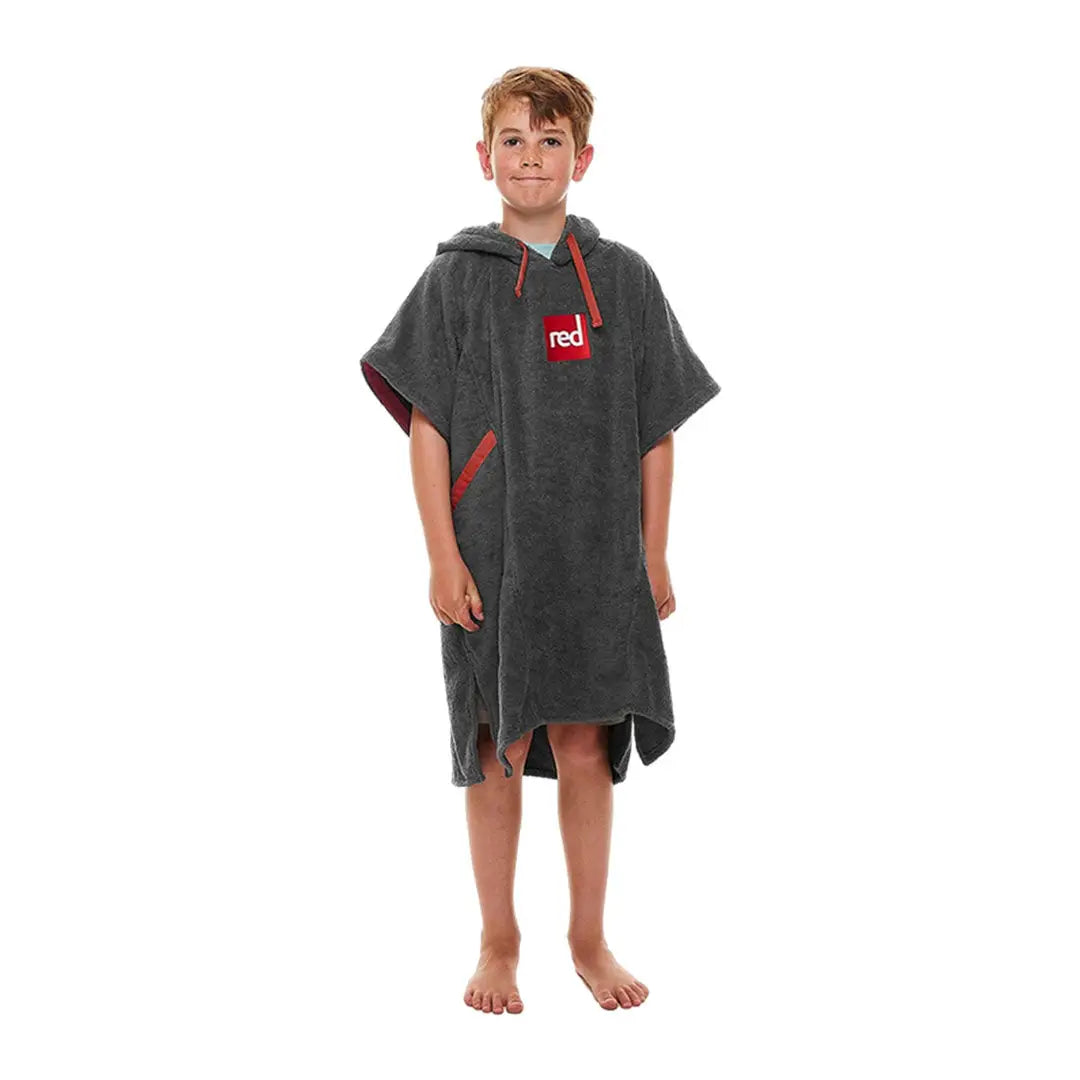 Young person in gray luxury towelling poncho with red logo and accents