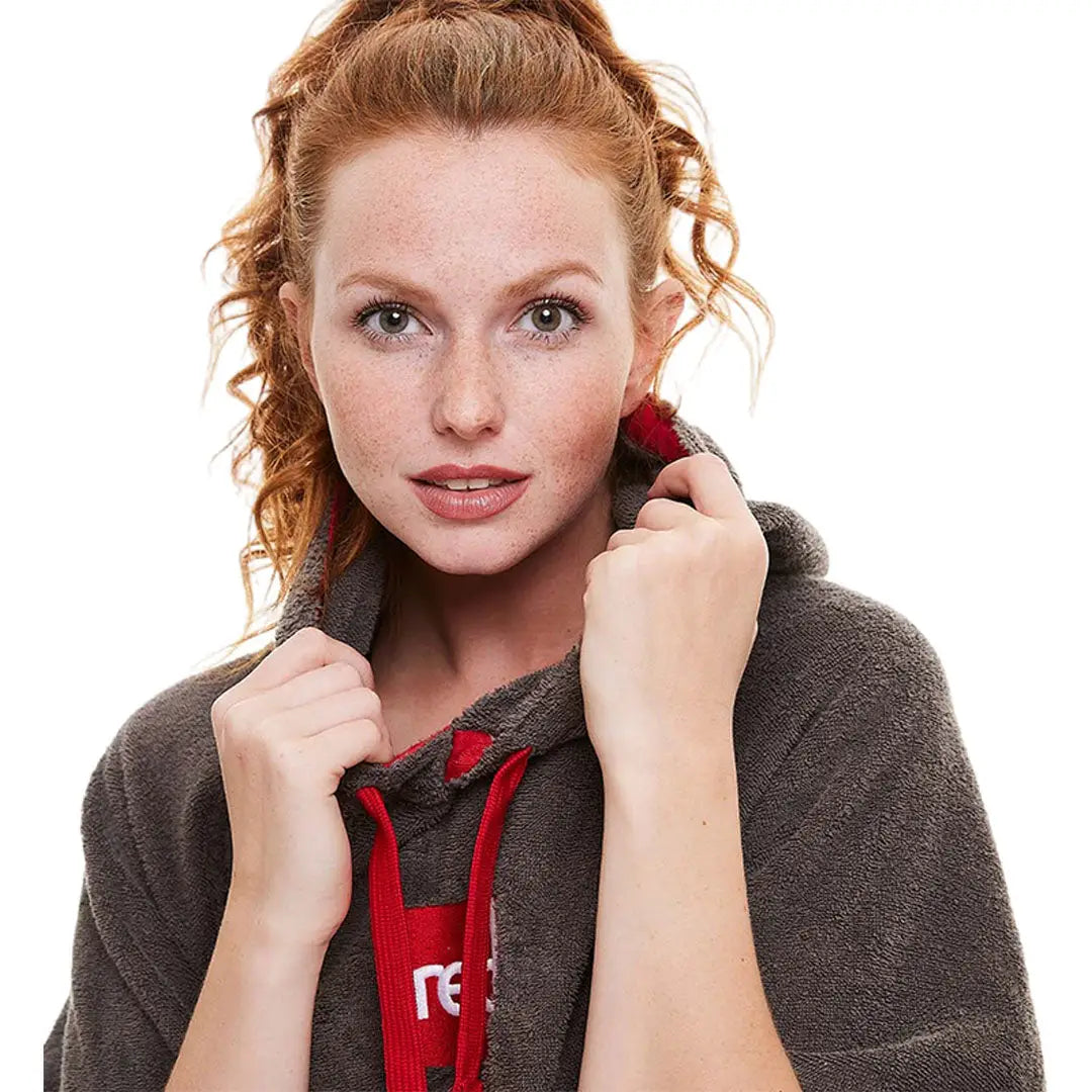 Woman with red hair in a cozy gray and red towelling change robe