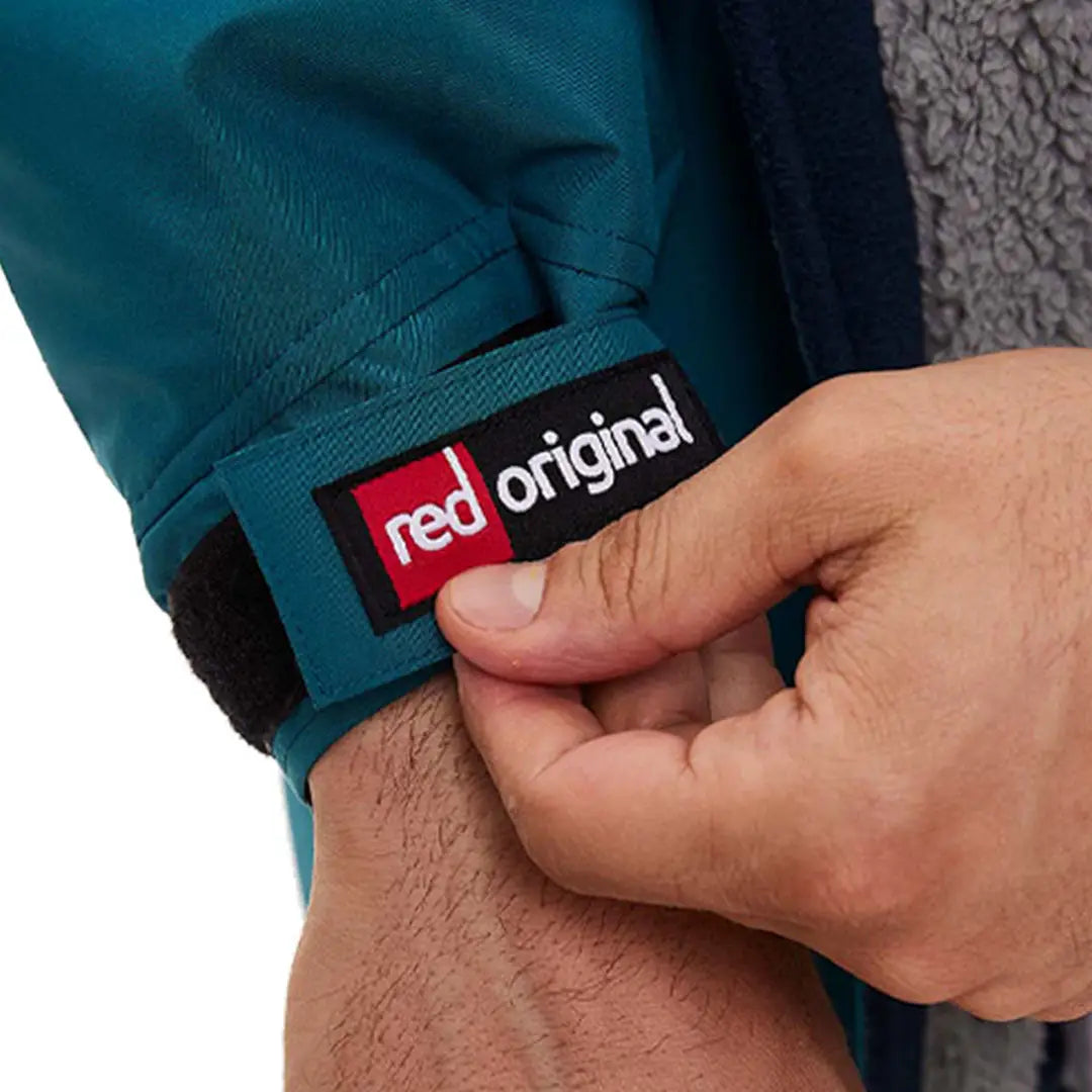 Clothing label of Red Pro Change jacket held between fingers by outdoor professionals