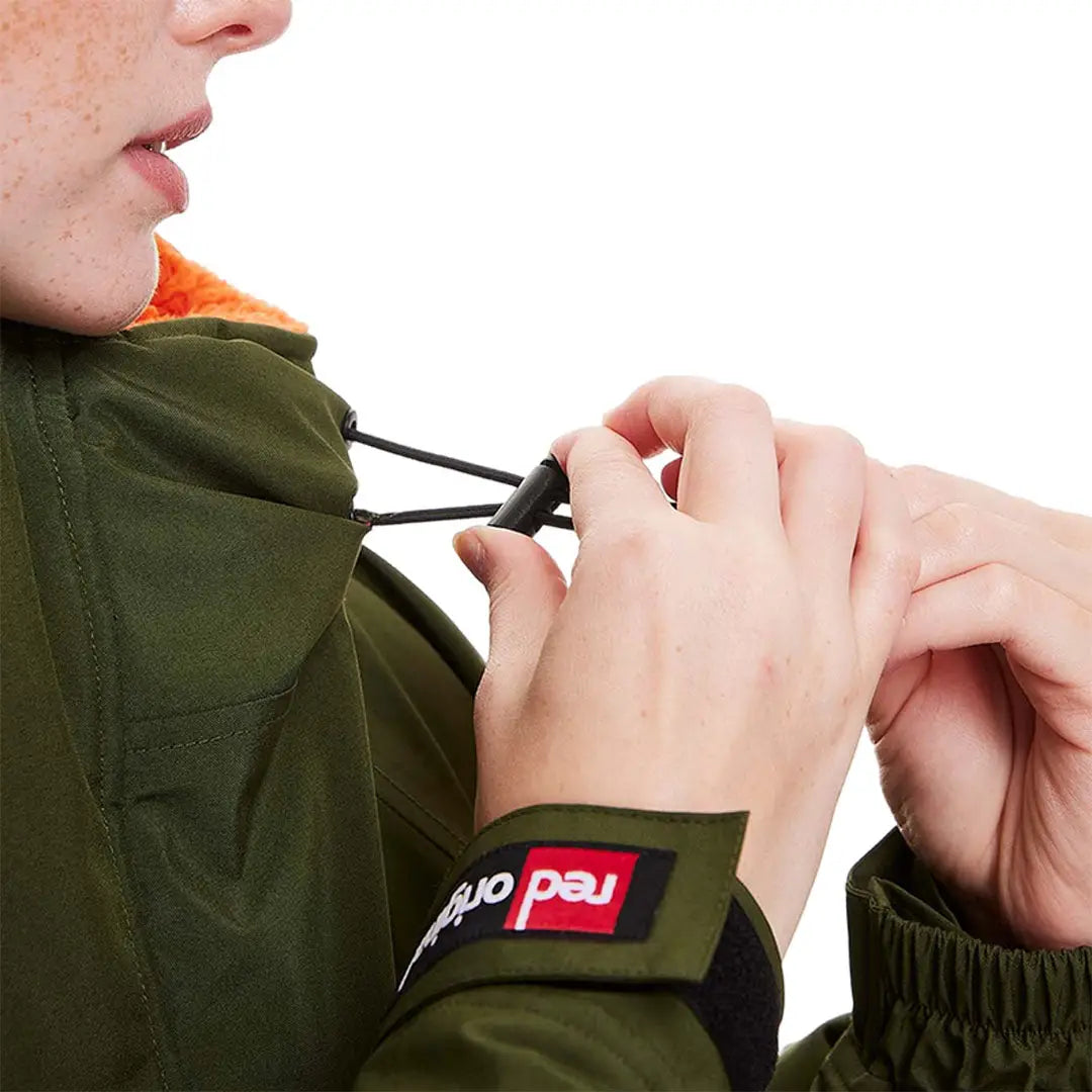 Hands adjusting a drawstring on a Green Red Pro Change Long Sleeve Evo Jacket