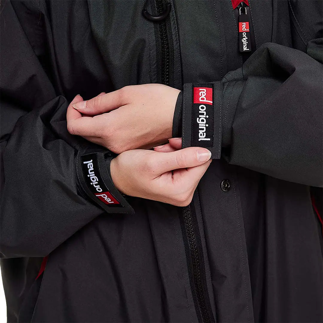 Hands adjusting the cuff of a black Red Pro Change Long Sleeve Evo Jacket