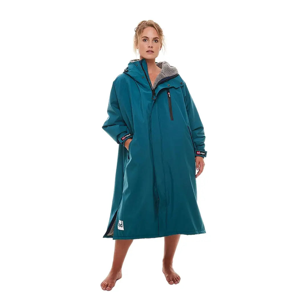 Teal waterproof poncho worn by a woman with Red Pro Change long sleeve jacket