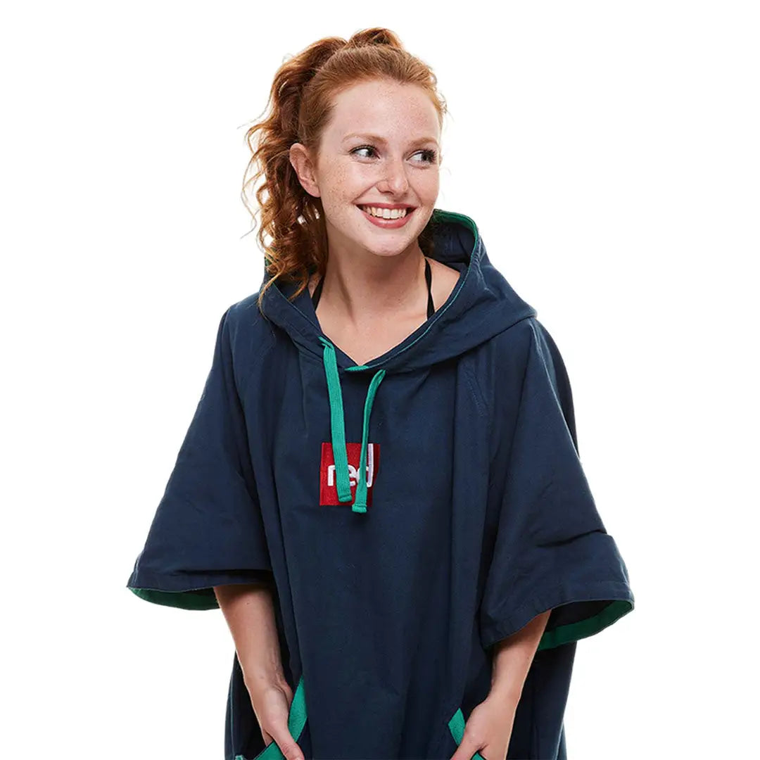 Woman in a navy blue hooded poncho styled as a microfibre changing robe with green trim