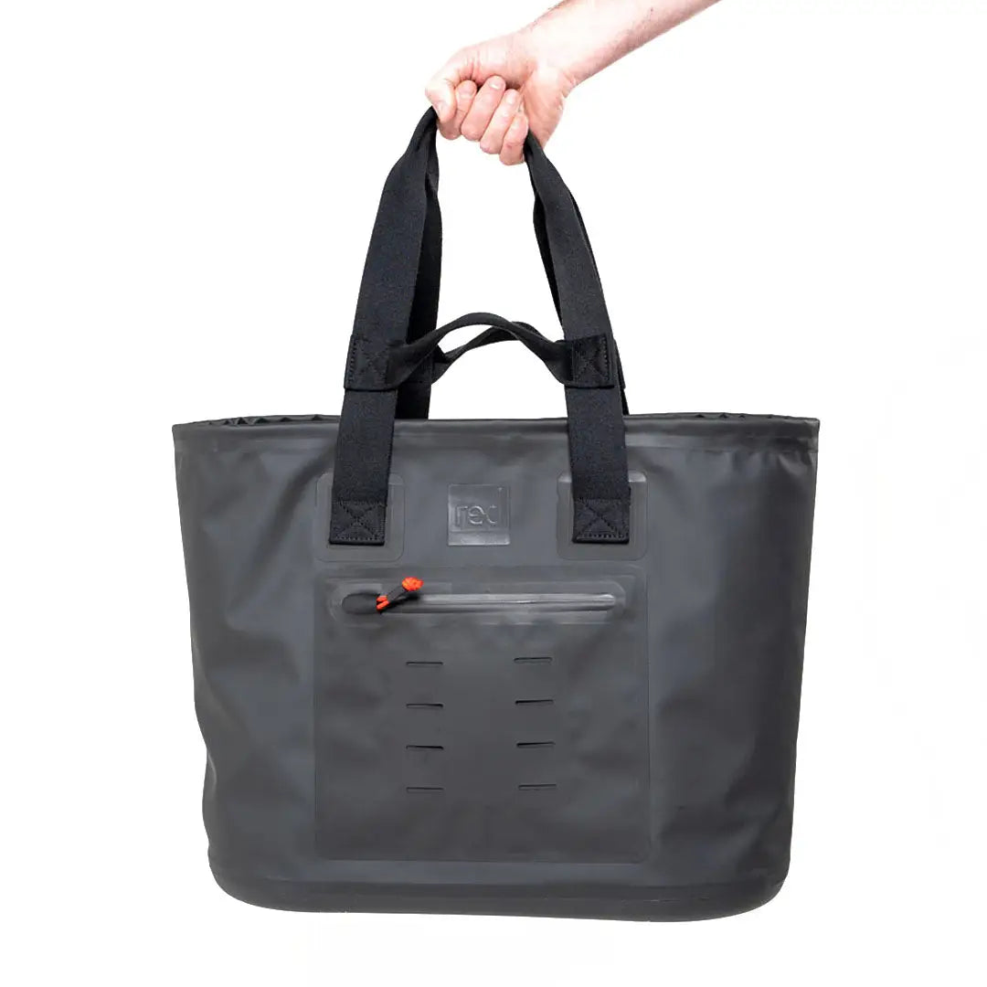 Hand holding a gray tote bag with black handles next to a Red Waterproof Tote Bag