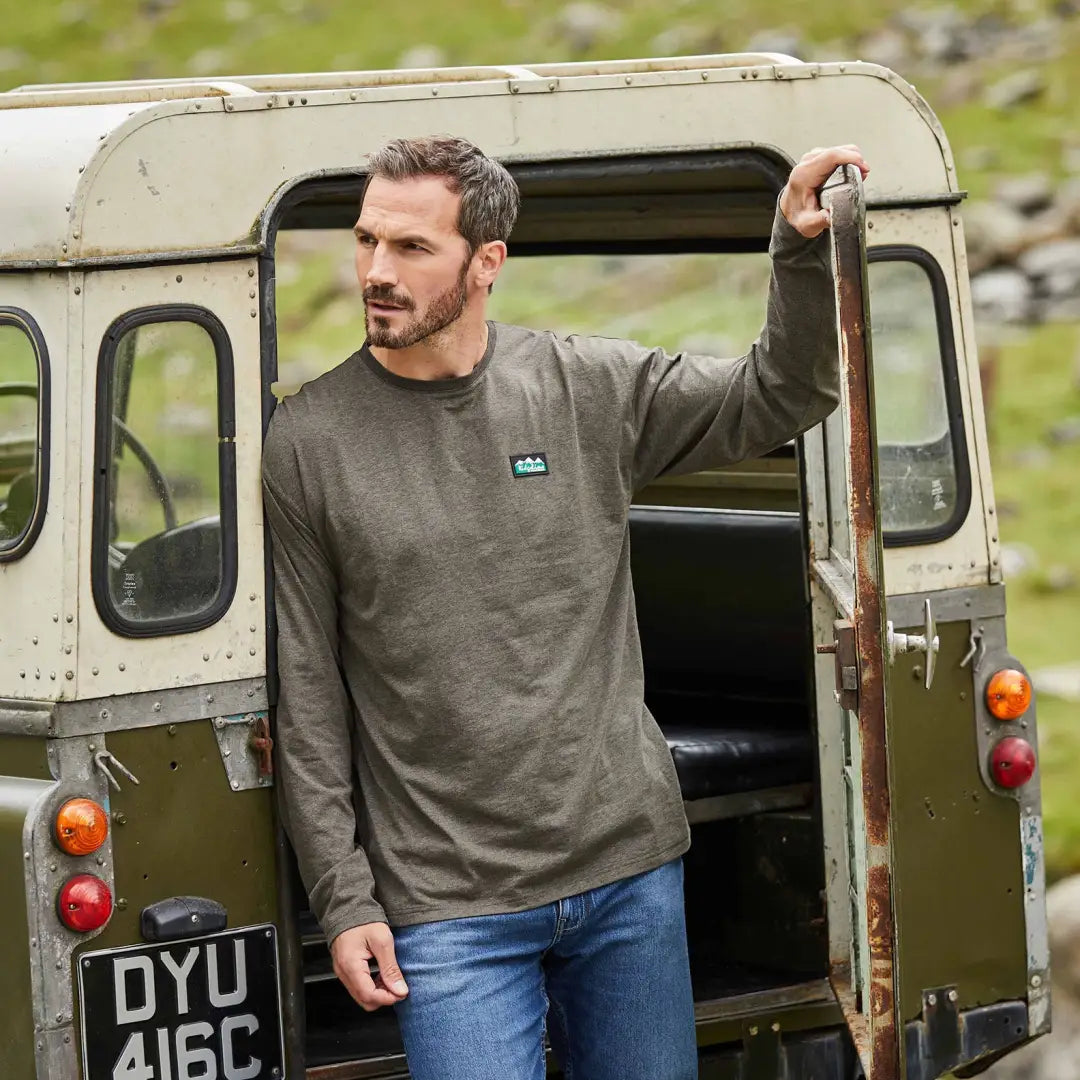 Man in doorway of vintage off-road vehicle, perfect for country clothing and outdoor hunting adventures