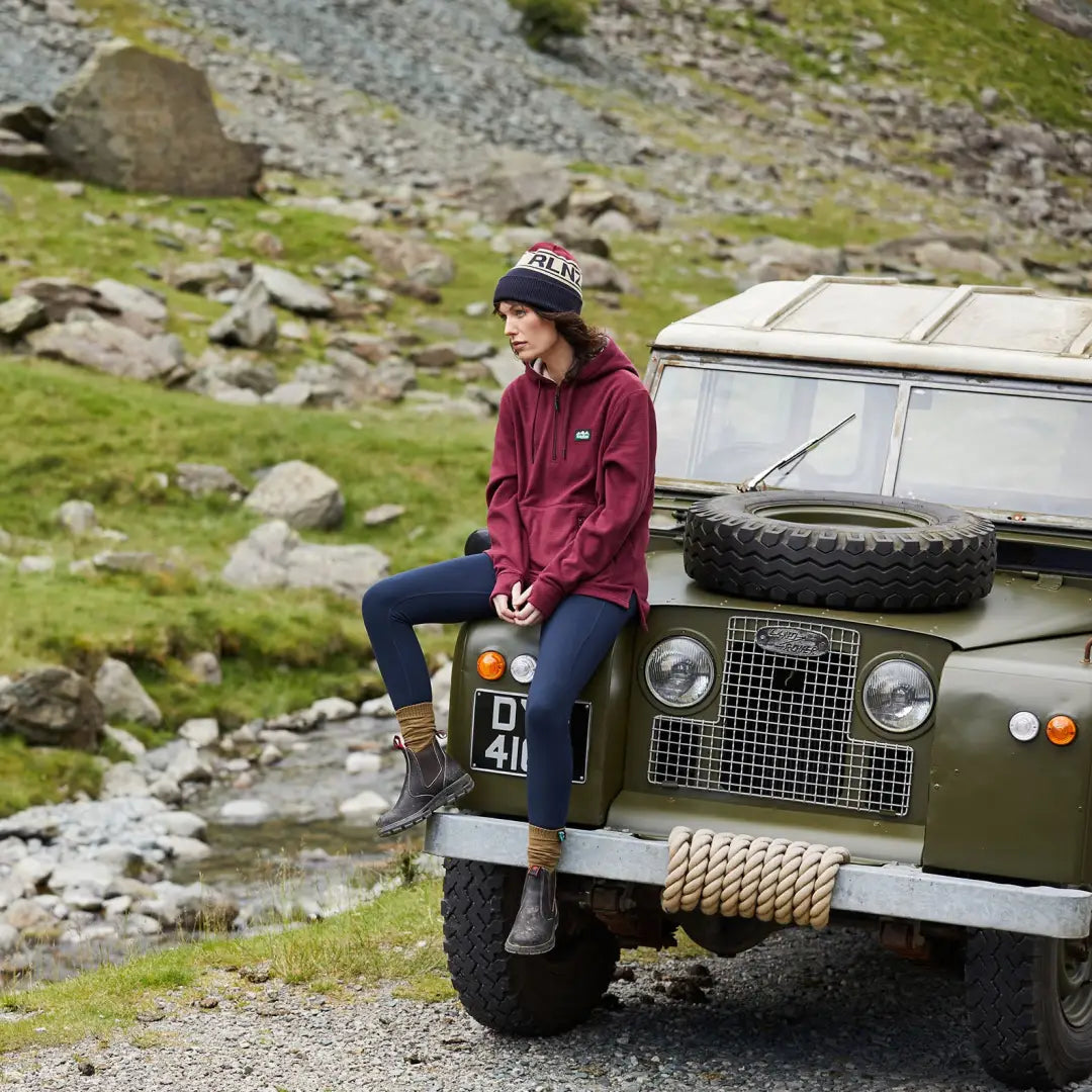 Vintage Land Rover off-road vehicle with a person in a stylish ladies ballistic hoodie