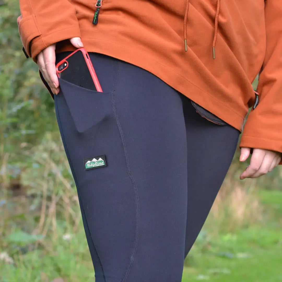 Black leggings with a green logo, perfect for Ridgeline Ladies Infinity style