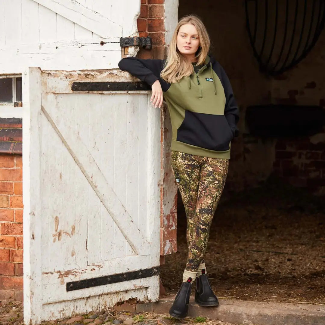 Woman in green and black hoodie with camouflage pants showcasing Ridgeline Infinity Leggings