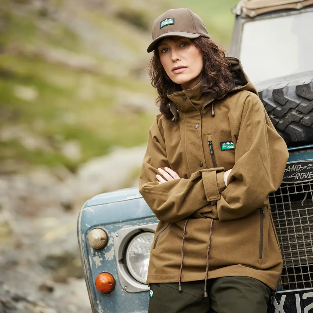 Person in Ridgeline Ladies Monsoon II Smock by rugged off-road vehicle with two hip zips