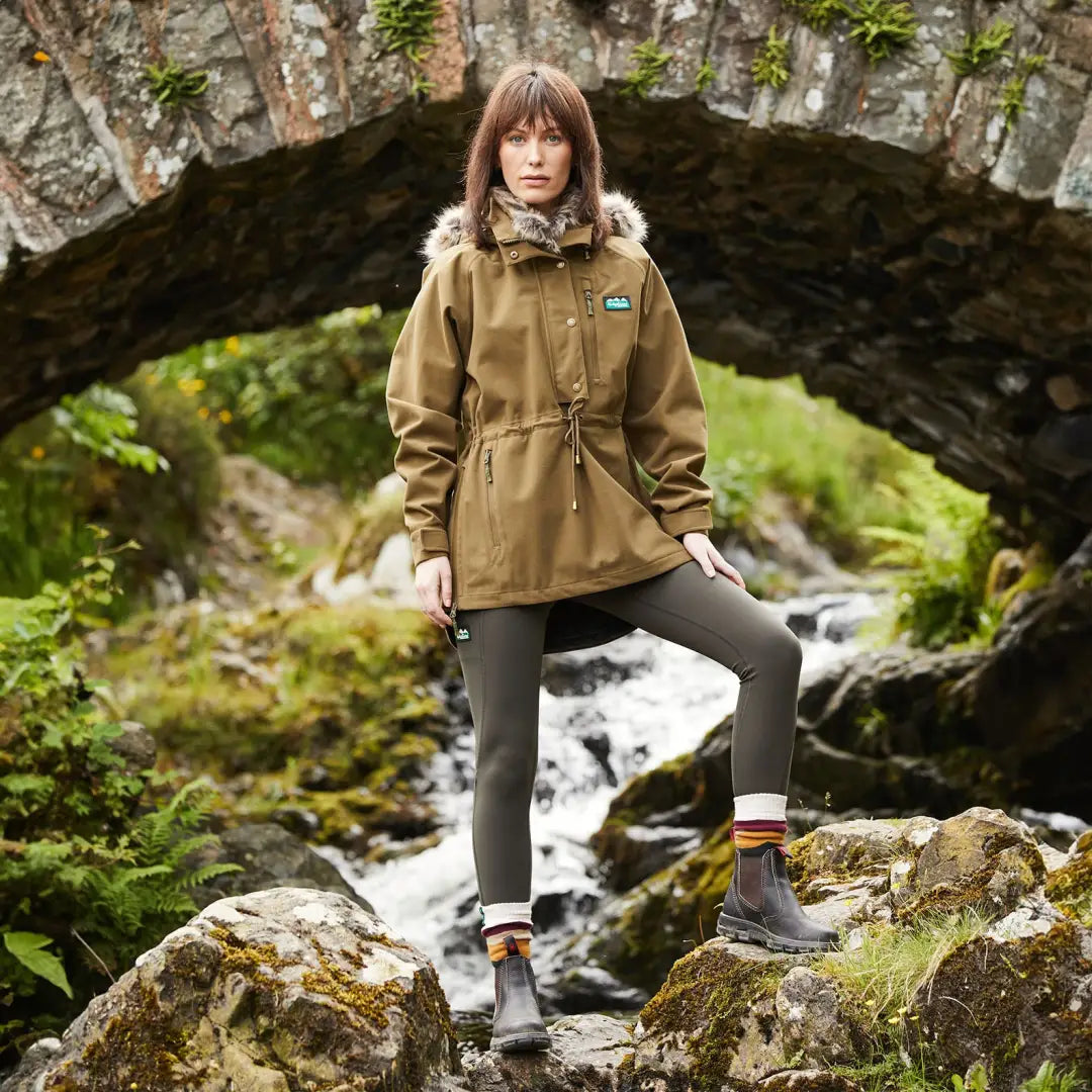 Woman in a tan parka rocks the Monsoon Nordic Smock by the stream