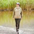 Person in a beige fleece pullover strolls the beach in a Ridgeline Ladies North Island Hoodie