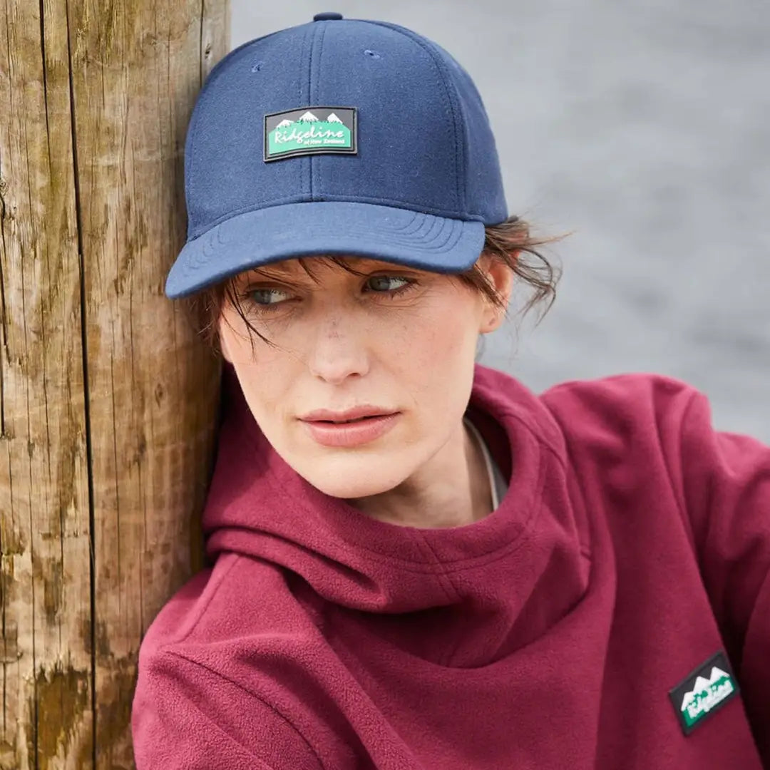 Blue baseball cap featuring a green mountain logo from the Monsoon Classic Cap collection