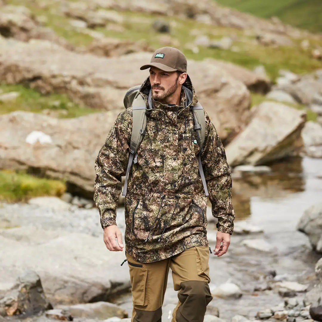 Hiker in camouflage wearing Ridgeline Monsoon Classic Smock in rocky outdoors