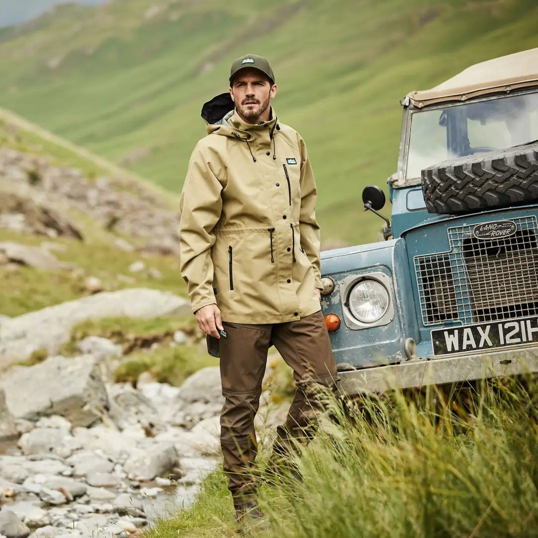 Man in outdoor gear by vintage off-road vehicle wearing Monsoon Nunatak Jacket