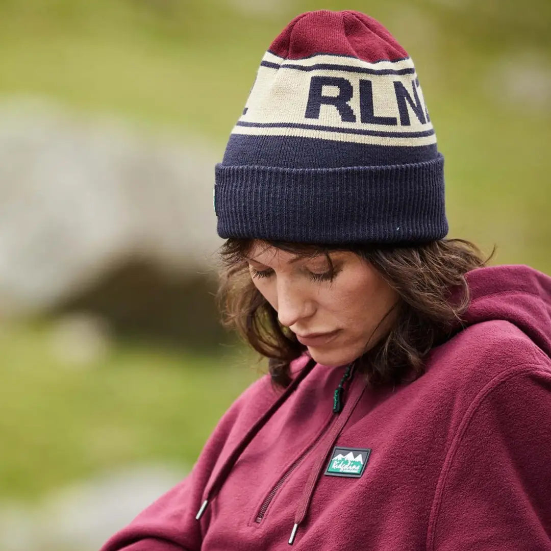 Woman rocking a burgundy and navy RLNZ Knitted Beanie with cool RLN text