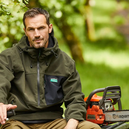 Chainsaw beside a person in a Ridgeline Tempest Smock on a sturdy surface