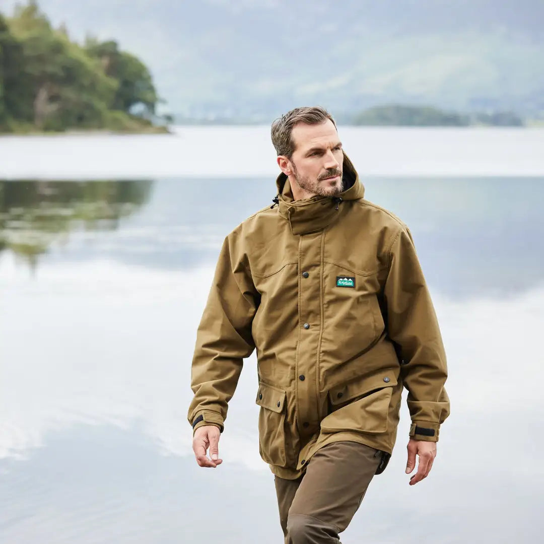 Man in a tan outdoor jacket enjoys nature near water in Ridgeline Torrent Euro III