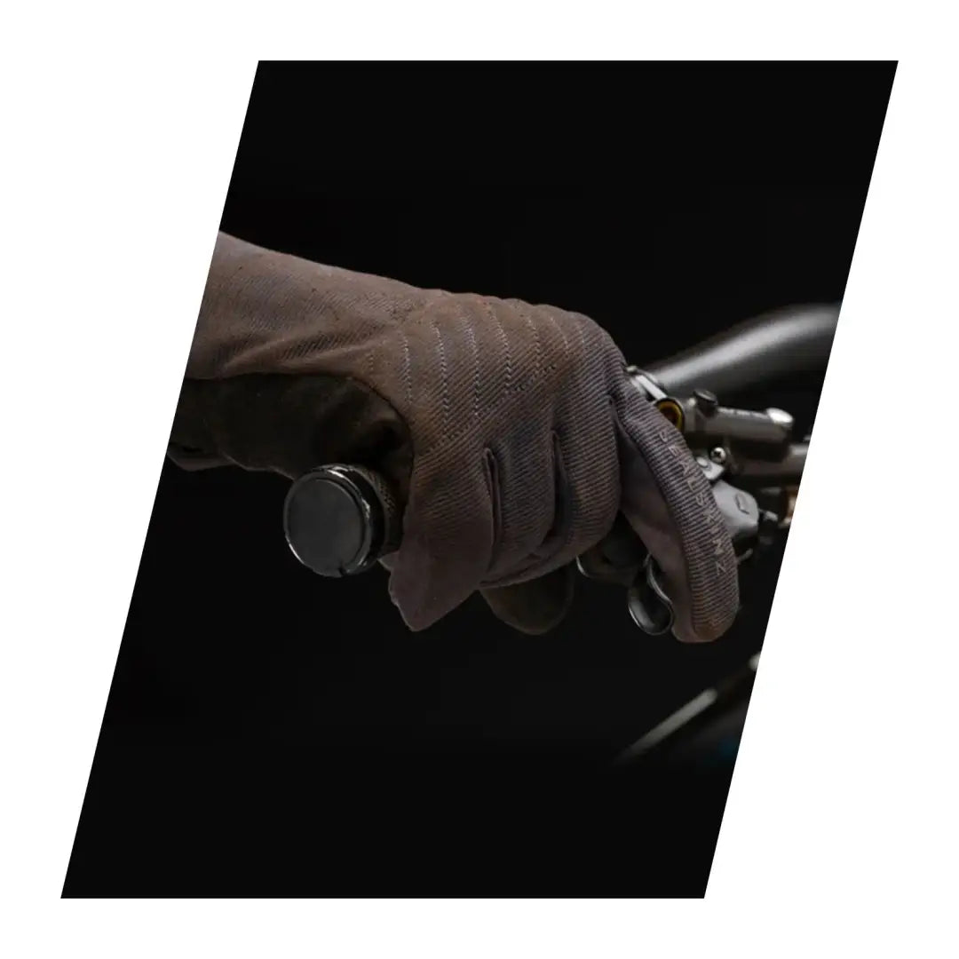 Hand in a leather Sealskinz Howe Glove gripping a motorcycle handlebar for weather multi-activity