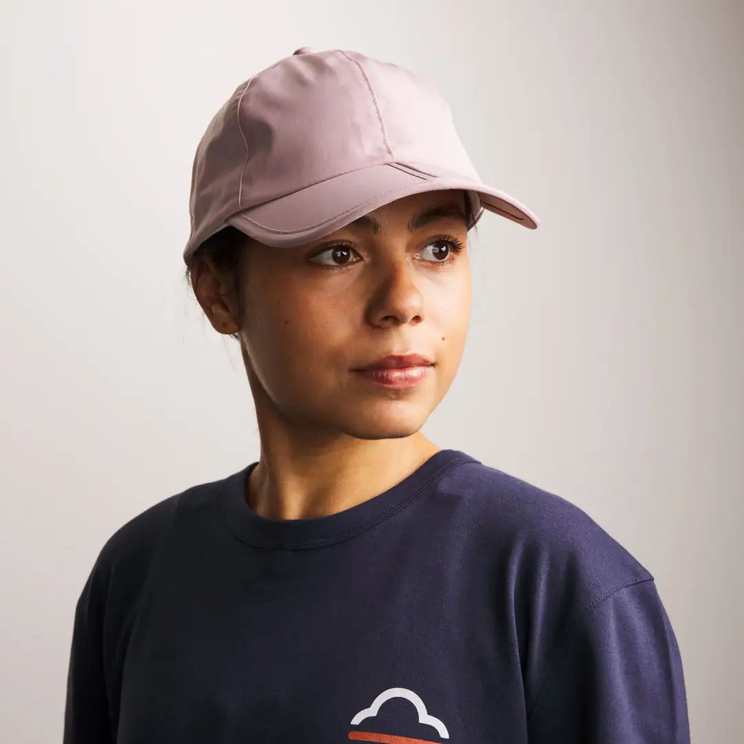 Person in a pink baseball cap and navy blue sweatshirt, perfect for country clothing outdoors