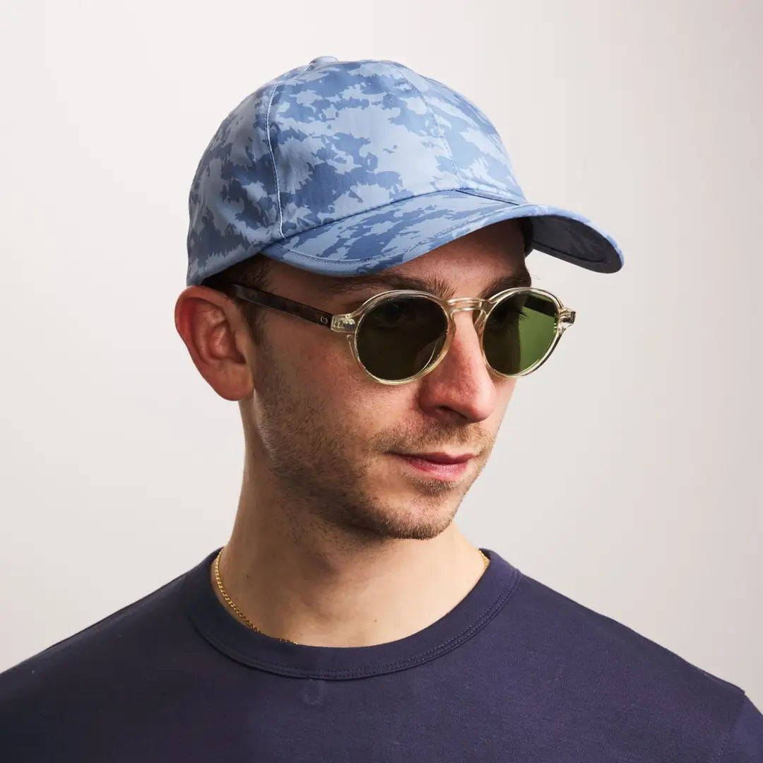 Man in blue camouflage cap and round sunglasses, perfect for outdoors and hunting