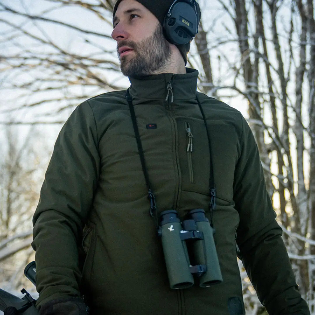 Man in a green Seeland Celsius Heat Jacket with binoculars around his neck