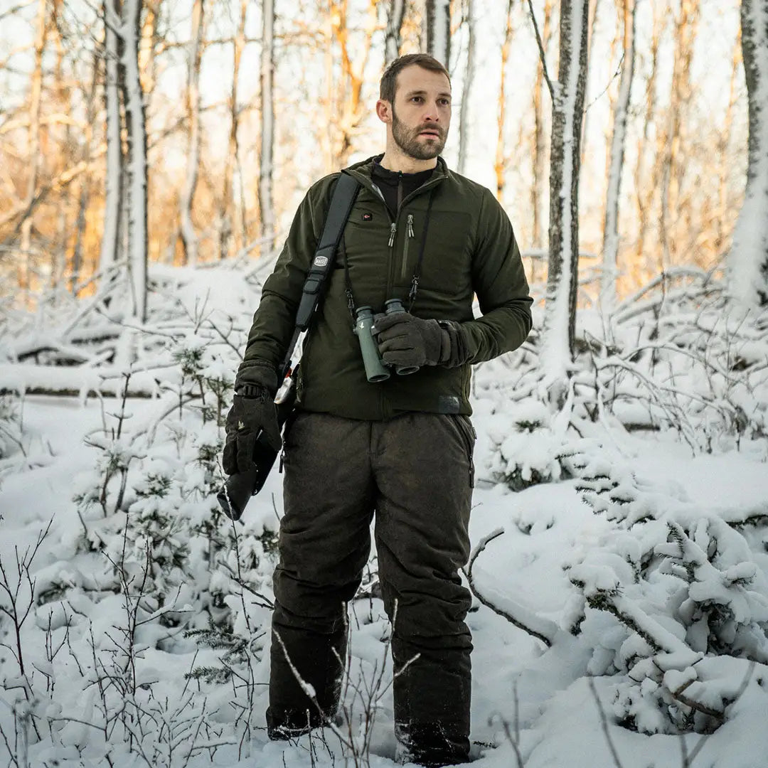 Man in snowy forest wearing Seeland Celsius Heat Jacket for outdoor adventures