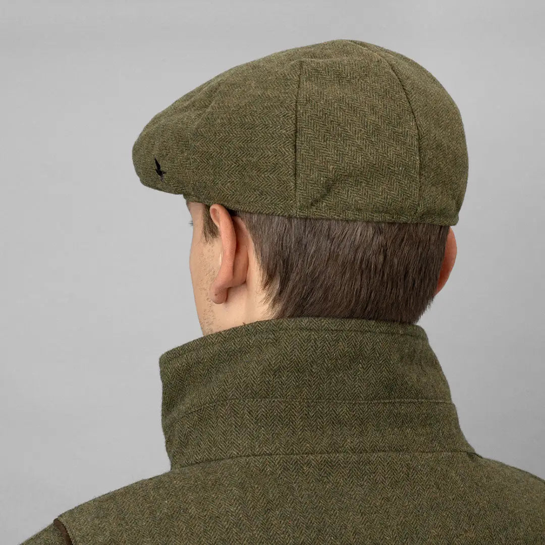 Olive green flat cap on a person, perfect for country clothing and hunting adventures