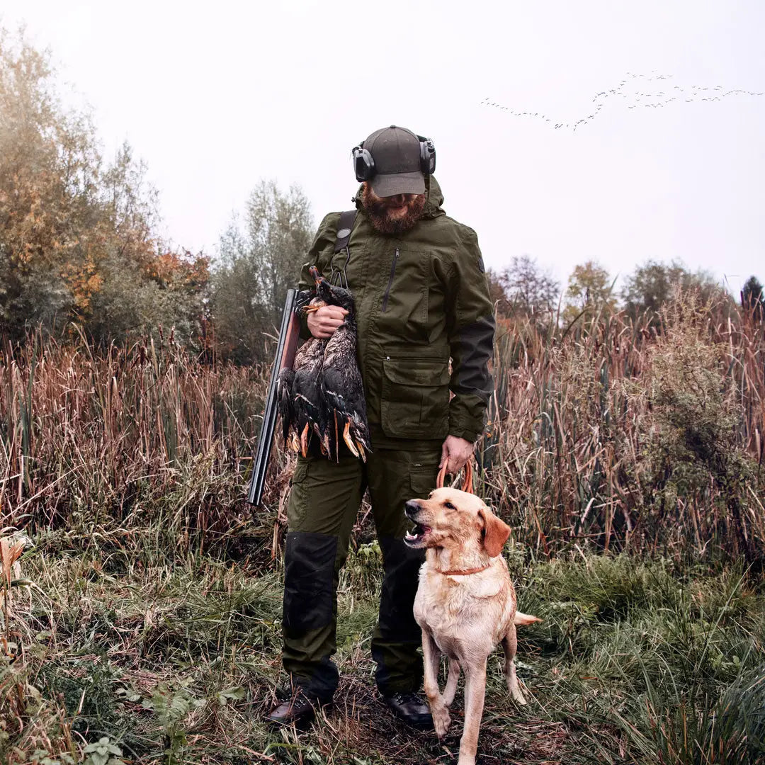 Hunter in Key-Point Reinforced Trousers with dog in a field ready for the hunt