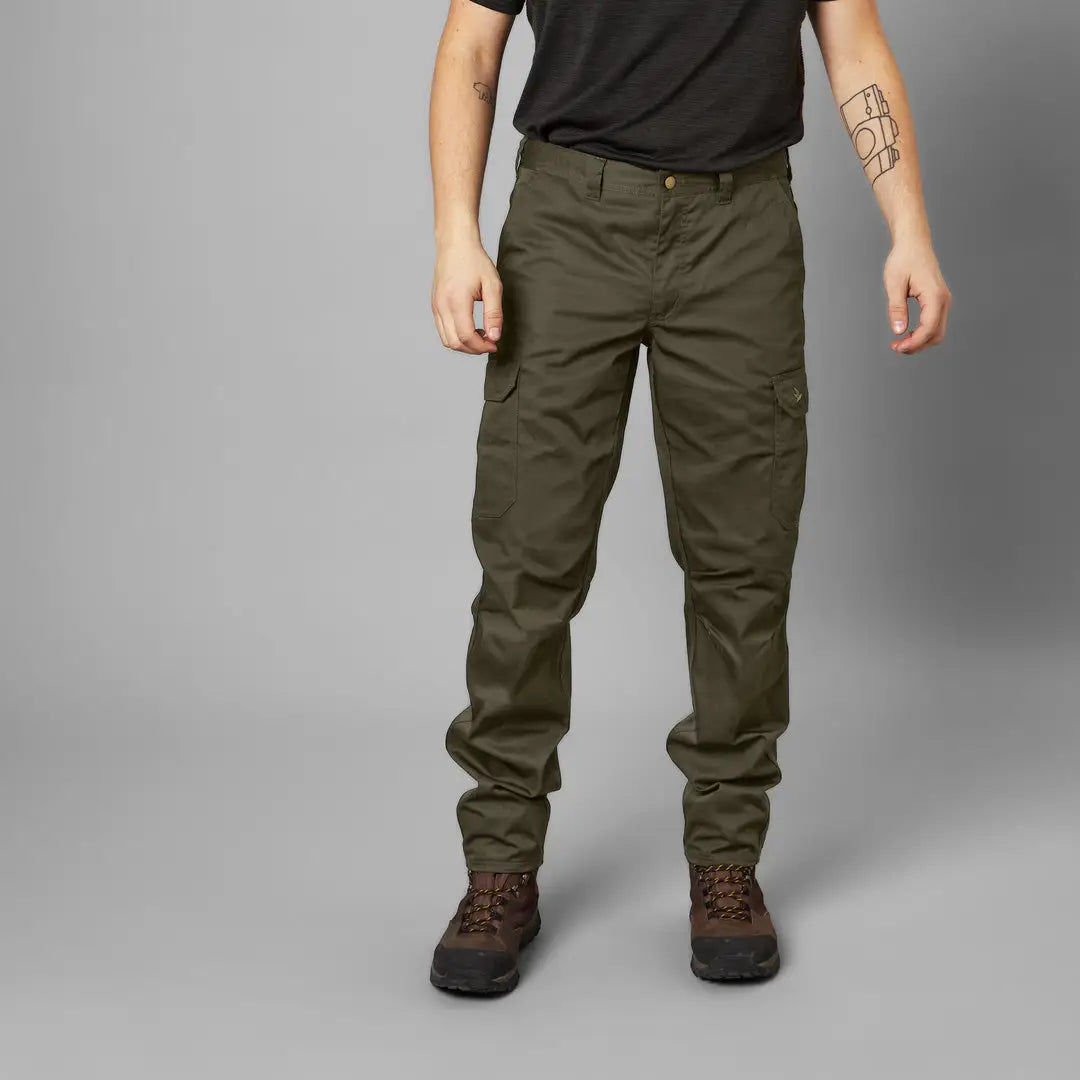 Person standing in Olive Green Seeland Oak Trousers showcasing style and comfort