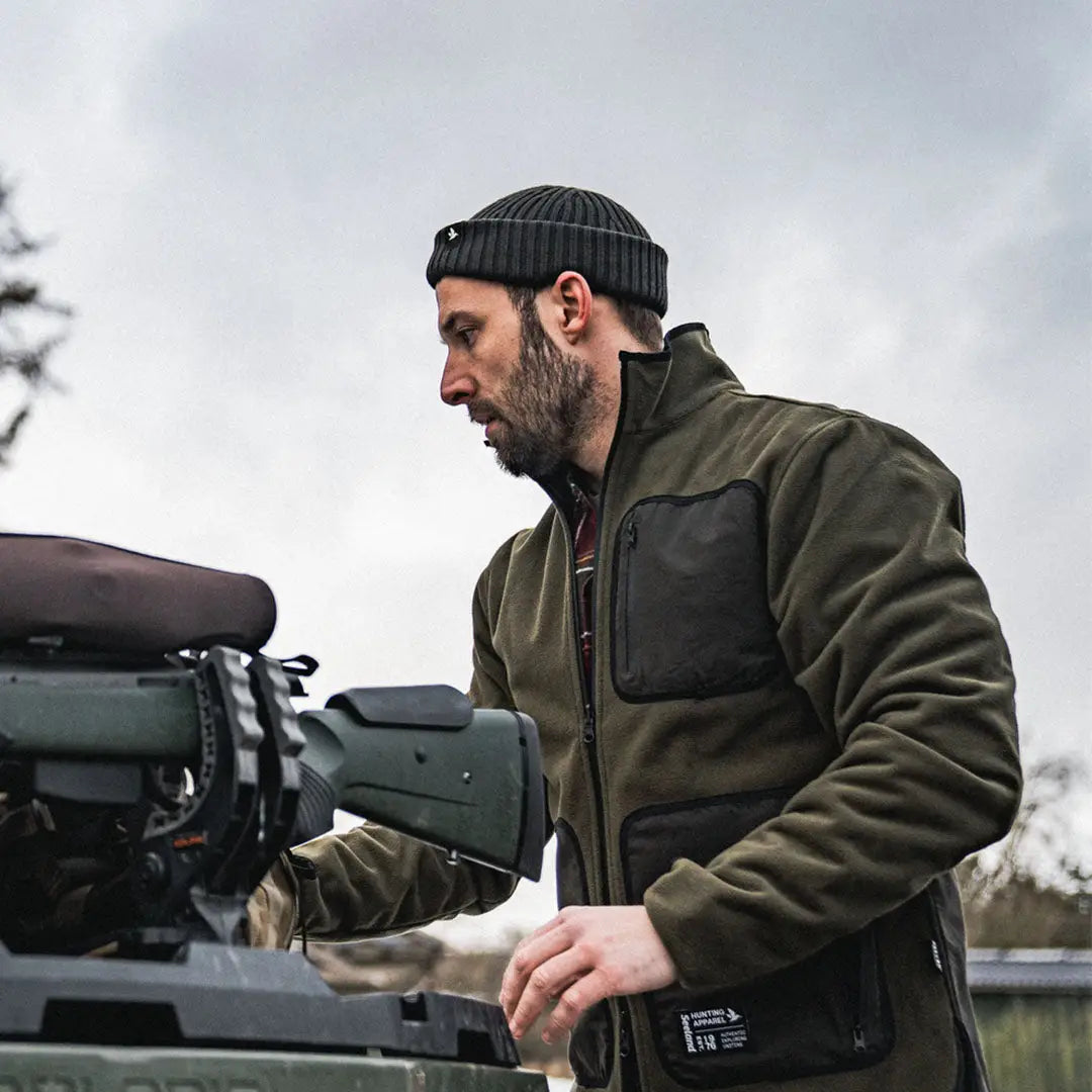 Bearded man in Seeland Rogue Reversible Fleece fixing a vehicle engine