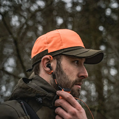 Bearded man in outdoor gear wearing an orange and black Seeland Trax Cap